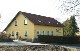 Gelbes Gebäude mit der Aufschrift 'Pension Praschak'.