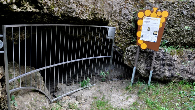Entrance to the R&ouml;schitz mussel cave with grating and information board.