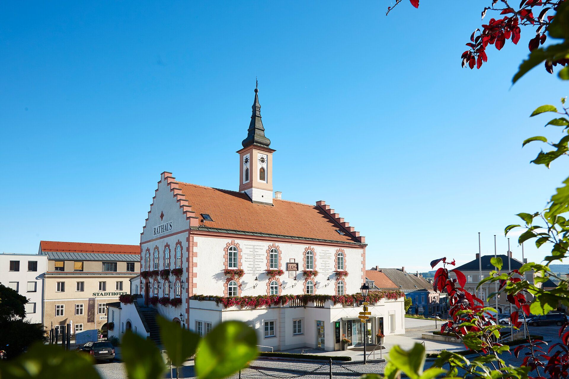 Die charmante Stadtmauerstadt verzaubert mit ihrem historischen Flair und der malerischen Architektur. Die bunten Blumen, die die Fenster schmücken, verleihen dem Gebäude eine einladende Atmosphäre, während die klare, blaue Himmel über der Stadt strahlt. Ein perfekter Ort, um die Schönheit der Umgebung zu genießen und in die Geschichte einzutauchen.