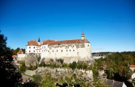 Die majest&auml;tische Burg Raabs thront stolz auf einem Felsen und bietet einen atemberaubenden Blick auf die umliegende Landschaft. Umgeben von &uuml;ppigem Gr&uuml;n und bl&uuml;henden B&auml;umen, strahlt sie eine Atmosph&auml;re von Geschichte und Abenteuer aus, die jeden Besucher in ihren Bann zieht.