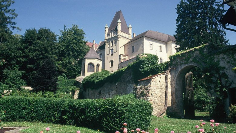 Schloss Maissau mit Garten und Blumen im Vordergrund.