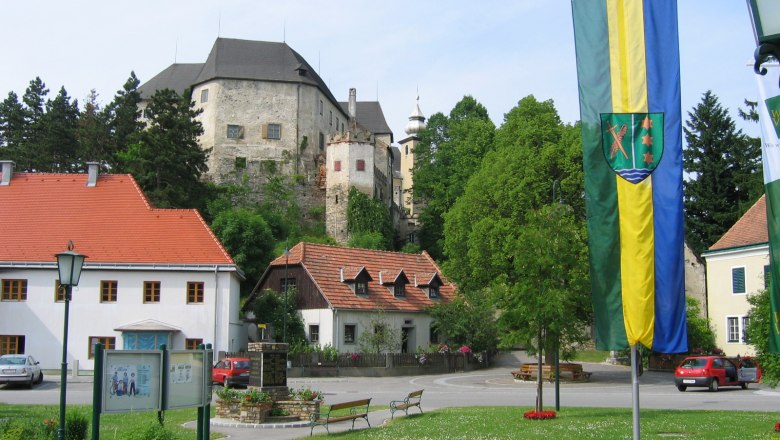 Hauptplatz in Albrechtsberg mit Schloss im Hintergrund und Fahne im Vordergrund.