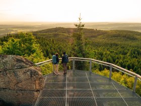 Zwei Frauen stehen auf der Aussichtsplattform am Nebelstein und genie&szlig;en den weiten Ausblick &uuml;ber die Waldlandschaft