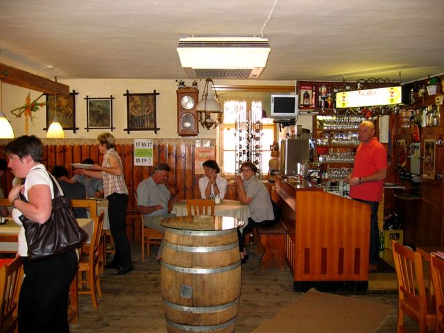 Innenansicht eines traditionellen Gasthofs mit Holzmöbeln und Bar.