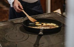 In einer gemütlichen Küche wird mit Hingabe ein traditionelles Gericht zubereitet. Der Duft von frisch gebratenem Karpfen erfüllt den Raum und weckt die Vorfreude auf ein köstliches Mahl. Hier erleben Besucher die Kunst des Kochens in einer einladenden Atmosphäre.