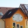 Gebäude mit Schild '1. Waldviertler Kinderbauernhof', Solarpanelen auf dem Dach.