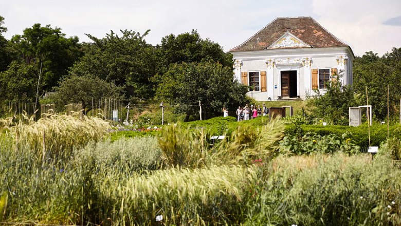 Historic building in the ARCHE NOAH show garden with lush vegetation in the foreground.