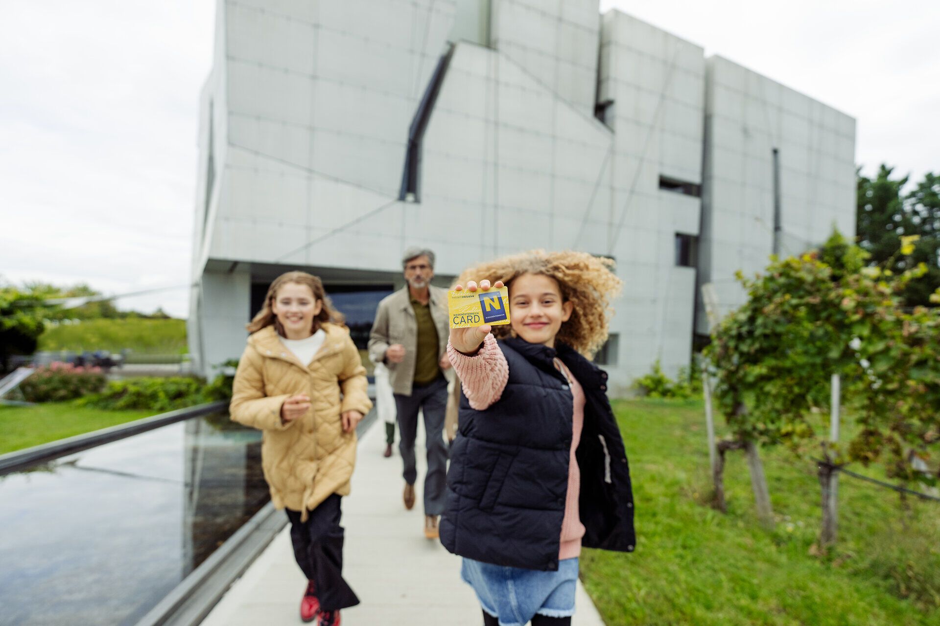 Eine fröhliche Familie genießt einen aktiven Tag im Freien, während sie mit der Niederösterreich CARD die Umgebung erkundet. Die Kinder strahlen vor Freude, während sie die Natur und die Architektur der Umgebung bewundern. Ein unvergessliches Erlebnis für Groß und Klein, das die Schönheit des Waldviertels in vollen Zügen zelebriert.