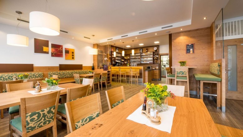 Innenansicht eines gemütlichen Gasthauses mit Holzmöbeln und Bar.