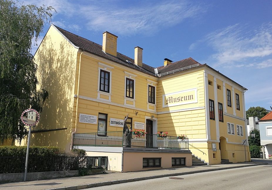 Gelbes Gebäude mit der Aufschrift 'Museum' und 'Zeitbrücke'.