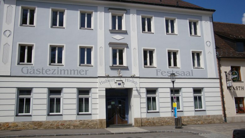 Fassade eines Gasthauses mit der Aufschrift 'G&auml;stezimmer' und 'Festsaal'.