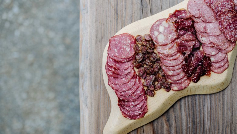 Different types of sausage on a wooden board.