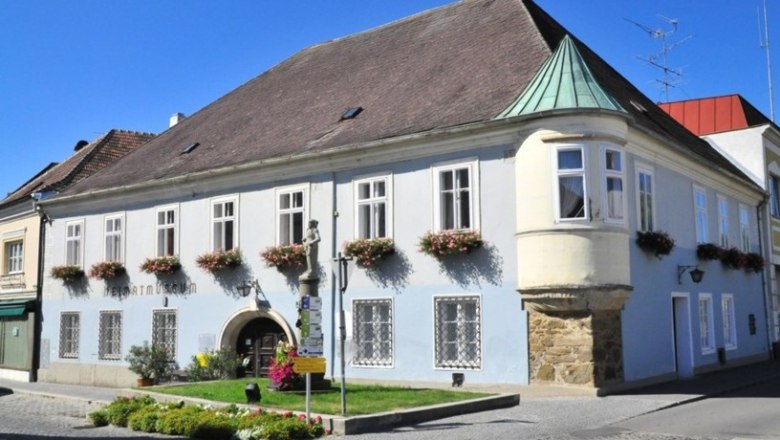 Historisches Gebäude mit blauer Fassade und Blumenkästen, Heimatmuseum Langenlois.