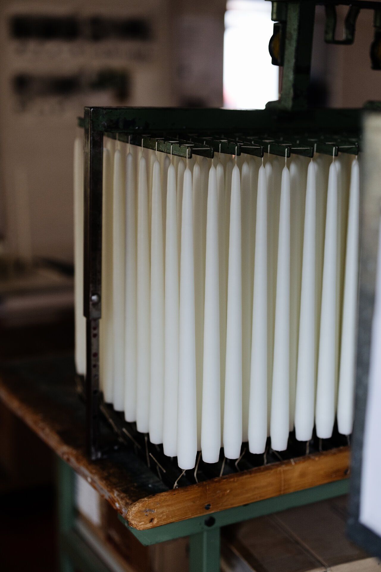 In einer charmanten Werkstatt reihen sich die handgefertigten Kochkerzen in perfekter Ordnung auf. Das sanfte Licht, das durch die Fenster strömt, verleiht dem Raum eine warme, einladende Atmosphäre, die die Kreativität und Tradition der Region widerspiegelt.