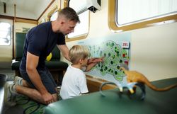 Ein Vater und sein Sohn erkunden gemeinsam die spannende Welt der Waldviertelbahn. Mit leuchtenden Augen zeigen sie auf die Karte und planen ihr nächstes Abenteuer in der Natur. Diese besondere Zeit stärkt die Bindung zwischen ihnen und lässt die Vorfreude auf den Ausflug wachsen.
