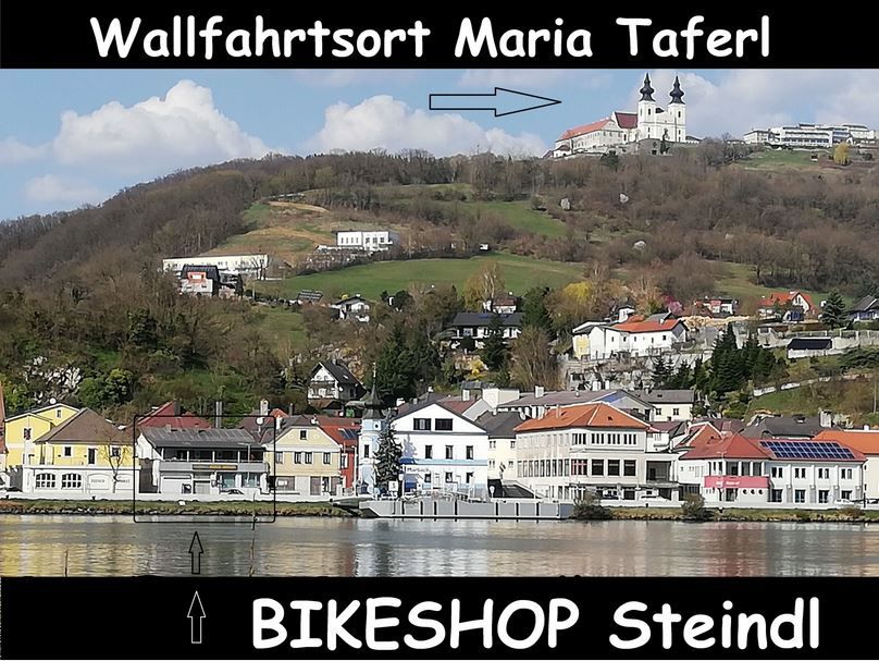 Blick auf Maria Taferl mit Kirche auf einem Hügel, darunter der Ort und ein Hinweis auf den Bikeshop Steindl.