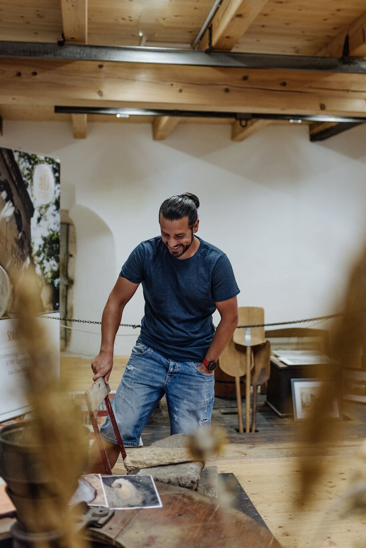 In der idyllischen Umgebung der aÖ Gillimühle genießt ein Besucher die faszinierenden Ausstellungsstücke und die handwerkliche Tradition. Die warmen Holztöne und die rustikale Atmosphäre laden dazu ein, die Geschichte und Kultur der Region zu entdecken.
