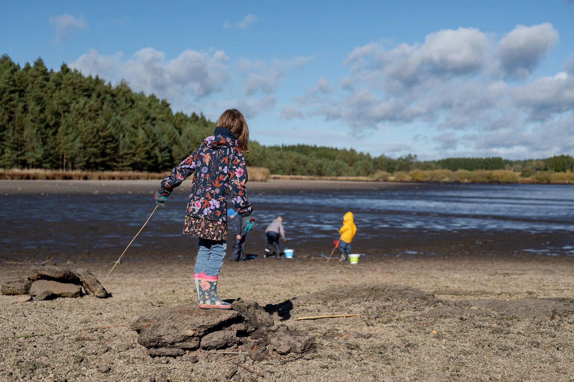 Ein strahlend blauer Himmel über dem Bruneiteich lädt zu einem unvergesslichen Tag in der Natur ein. Kinder erkunden das Ufer, während die sanften Wellen des Wassers die Umgebung in eine friedliche Atmosphäre tauchen. Hier, wo die Natur lebendig wird, können Besucher die Freude am Abfischen und die Schönheit der Landschaft erleben.