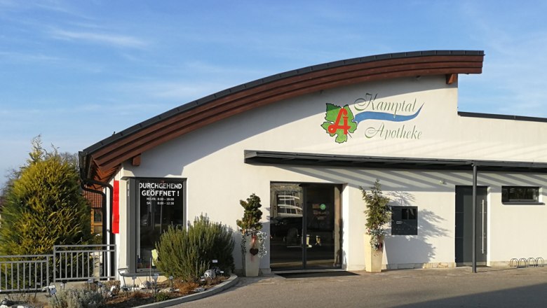 Außenansicht der Kamptal Apotheke in Langenlois mit modernem Design und Pflanzen vor dem Eingang.