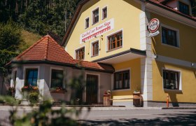 Gelbes Geb&auml;ude mit der Aufschrift 'Gasthof zur Roten S&auml;ge' und einem Kaiser-Bierschild.