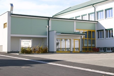 Außenansicht des Hallenbads Dobersberg mit gelben Türen und Fenstern.