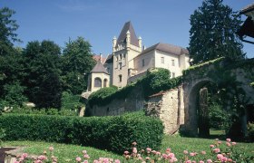 Schloss Maissau mit Garten und Blumen im Vordergrund.