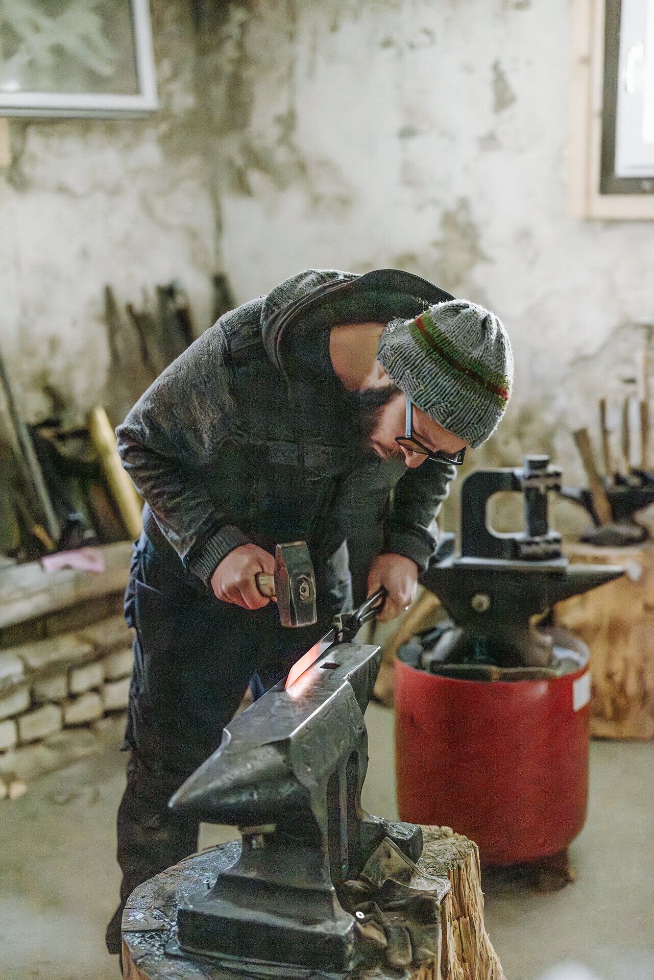In einer gemütlichen Werkstatt wird mit viel Leidenschaft und handwerklichem Geschick ein einzigartiges Messer gefertigt. Der warme Schein des Feuers und das rhythmische Hämmern des Schmieds schaffen eine einladende Atmosphäre, die die Kunst des Handwerks lebendig werden lässt.