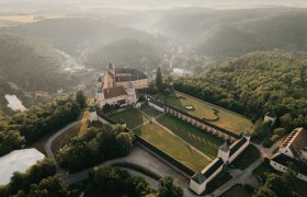 Luftaufnahme von Schloss Rosenburg umgeben von Wald und H&uuml;geln.