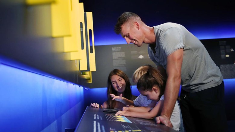 Eine Familie interagiert mit einer Ausstellung in einem Museum.