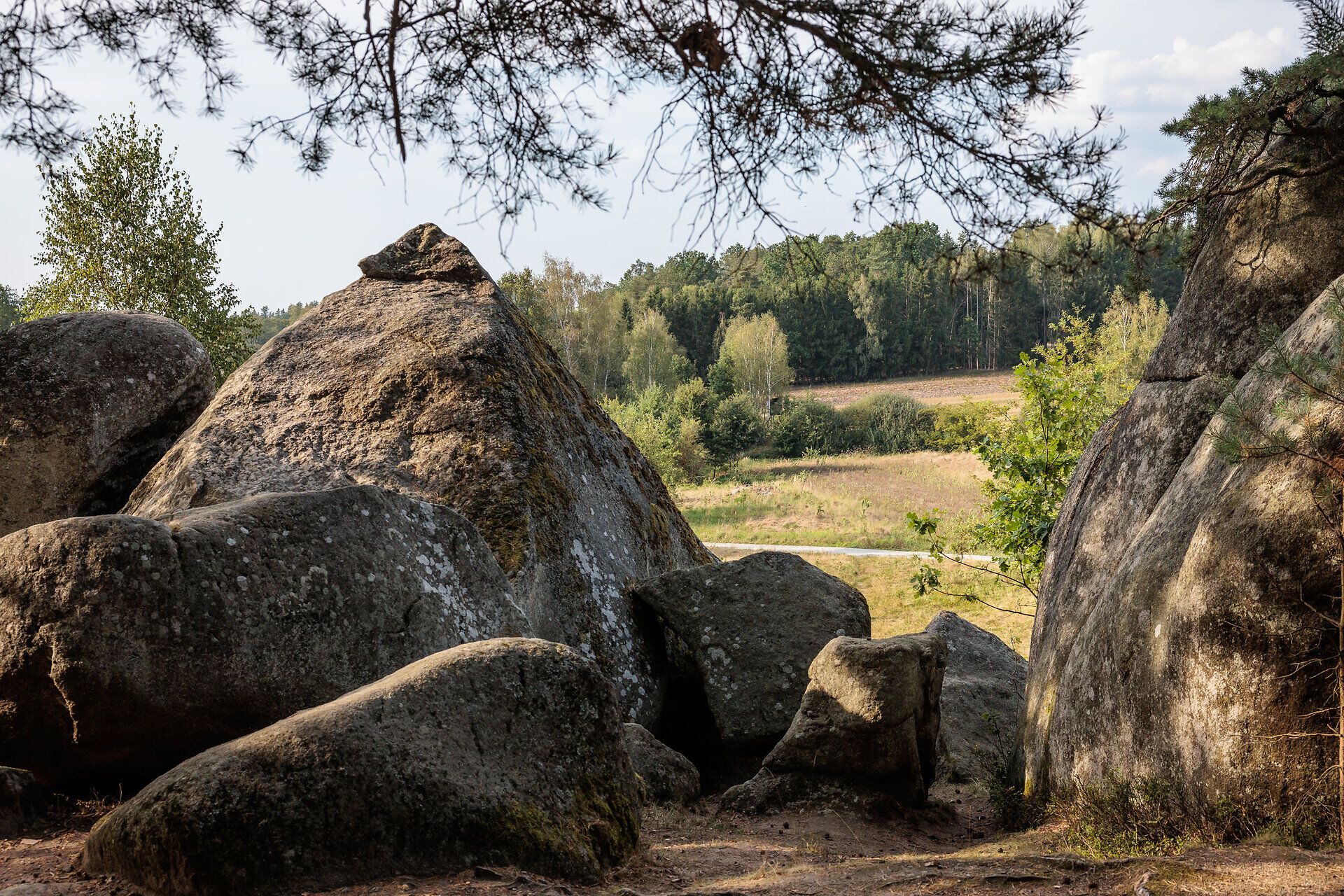 Im Naturpark Blockheide entfaltet sich eine beeindruckende Landschaft aus majestätischen Felsen und sanften Hügeln, die von üppigem Grün umgeben sind. Die ruhige Atmosphäre lädt dazu ein, die Seele baumeln zu lassen und die Schönheit der Natur in vollen Zügen zu genießen.