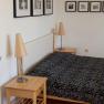 Schlafzimmer mit Doppelbett, Nachttischen und Wandbildern.