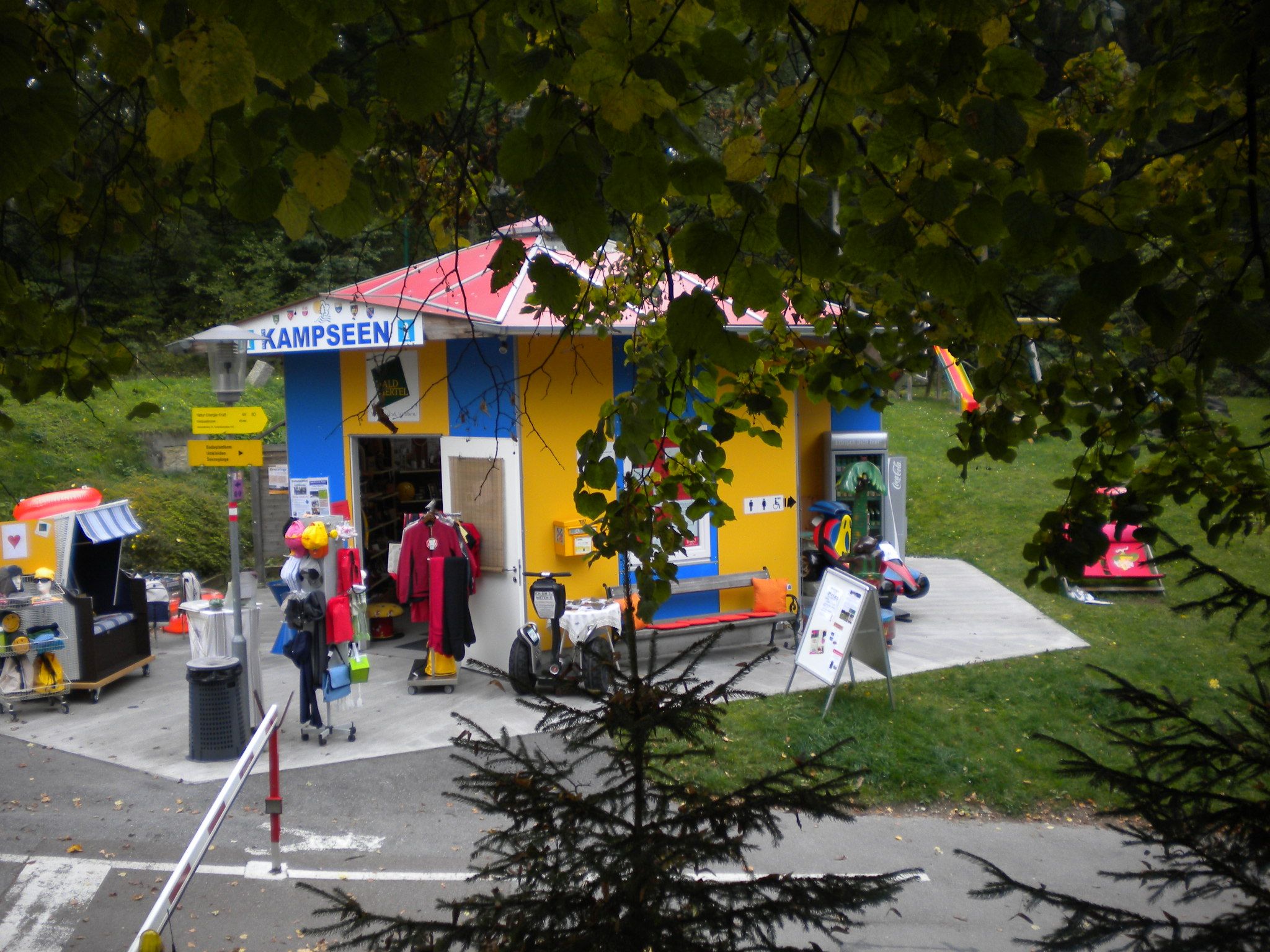 Kleines, buntes Infozentrum mit Spielzeug und Kleidung im Freien.