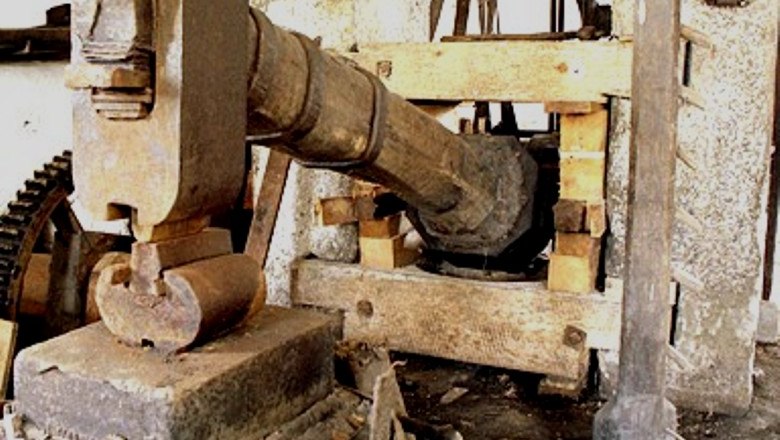 Historische Hammerschmiede mit großem Holzhammer und Metallamboss.