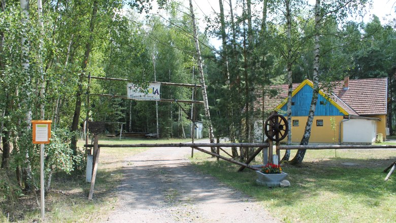 Eingang zu einem Lagerplatz mit einem gelben Gebäude im Hintergrund.