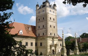 Renaissanceschloss Greillenstein mit Turm und Garten im Vordergrund.