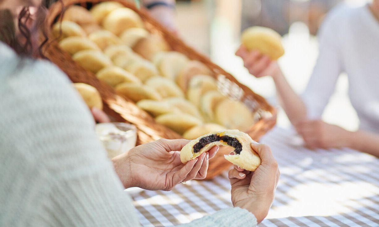 Inmitten der blühenden Mohnfelder genießen die Gäste frisch gebackene Köstlichkeiten und aromatischen Kaffee. Die entspannte Atmosphäre lädt dazu ein, die Schönheit der Natur und die Geselligkeit in vollen Zügen zu erleben.