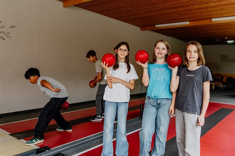 Kinder spielen Kegeln in einem Hotel.
