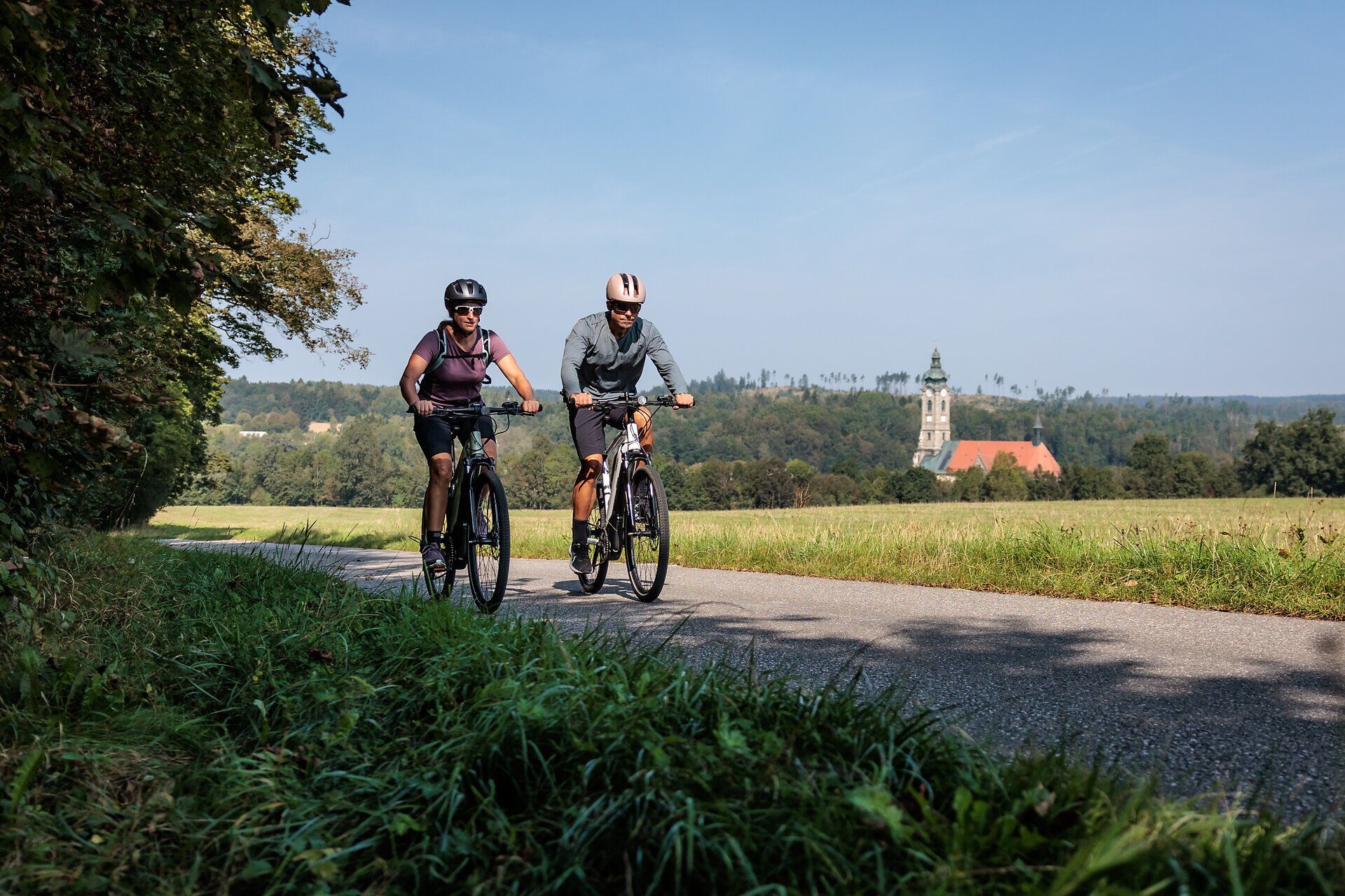 Radfahrer genießen die frische Luft und die malerische Landschaft entlang des Kamptal Radwegs. Umgeben von sanften Hügeln und üppigen Wiesen, strahlt die Umgebung eine einladende Ruhe aus, die zum Verweilen einlädt.