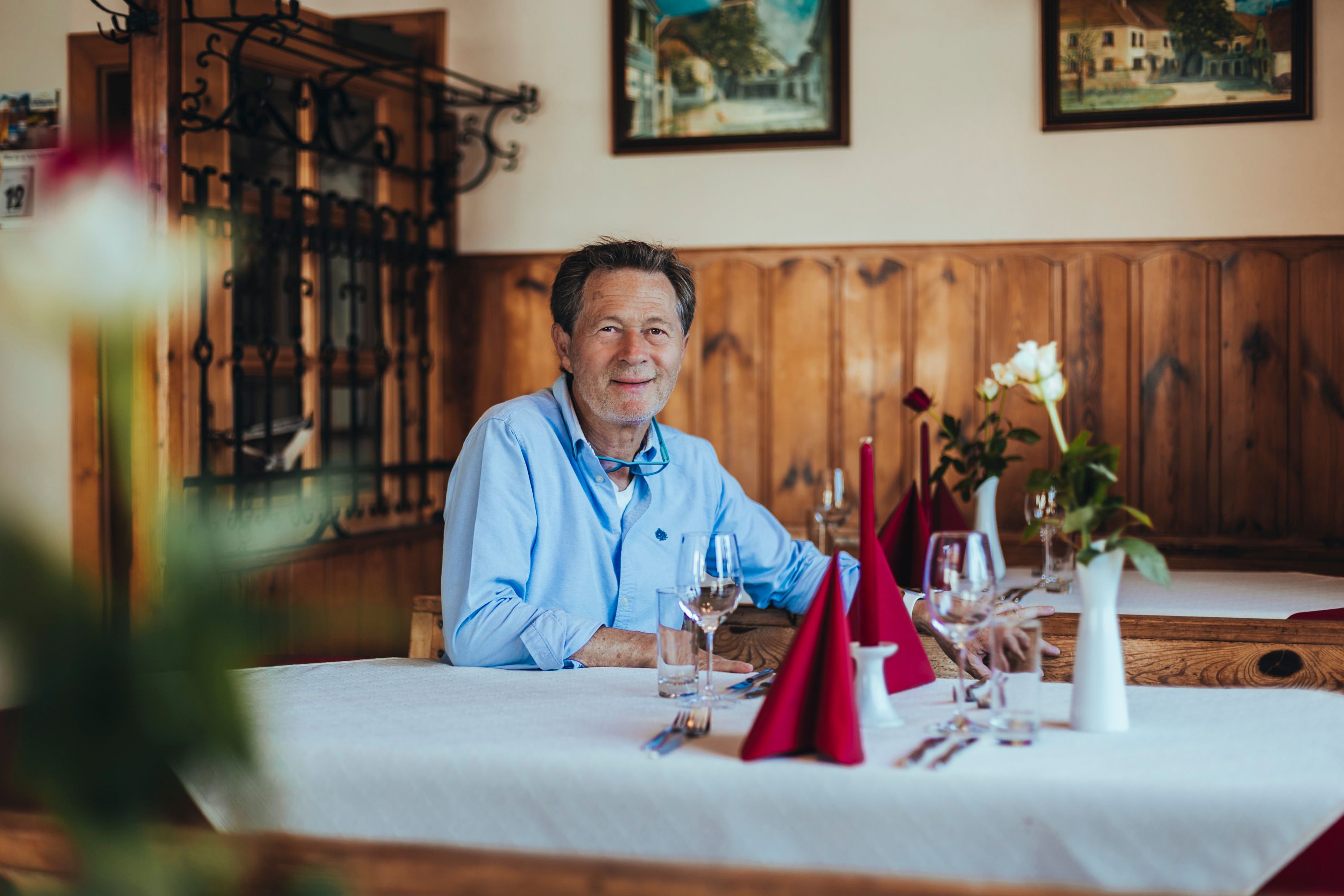 Karlheinz Ringl sitzt an einem gedeckten Tisch in seinem Gasthaus.