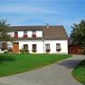 Ein traditionelles Bauernhaus mit Blumen an den Fenstern und einem gepflegten Garten.
