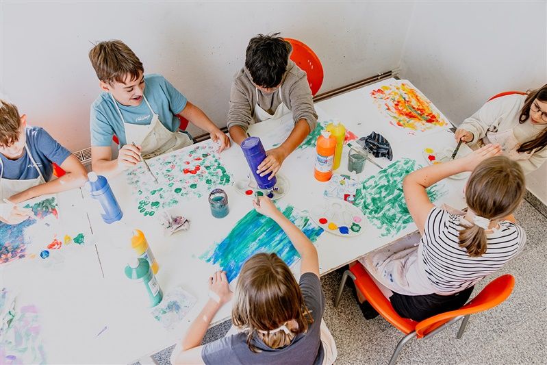 Kinder malen an einem Tisch im Kunstmuseum Schrems.
