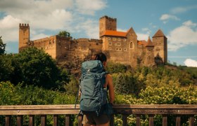 Wandererin, die zur malerischen Burg Hardegg schaut