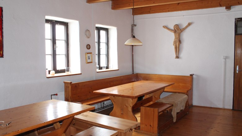 Rustikaler Raum mit Holzmöbeln, Holzbalkendecke und Wanddekoration.