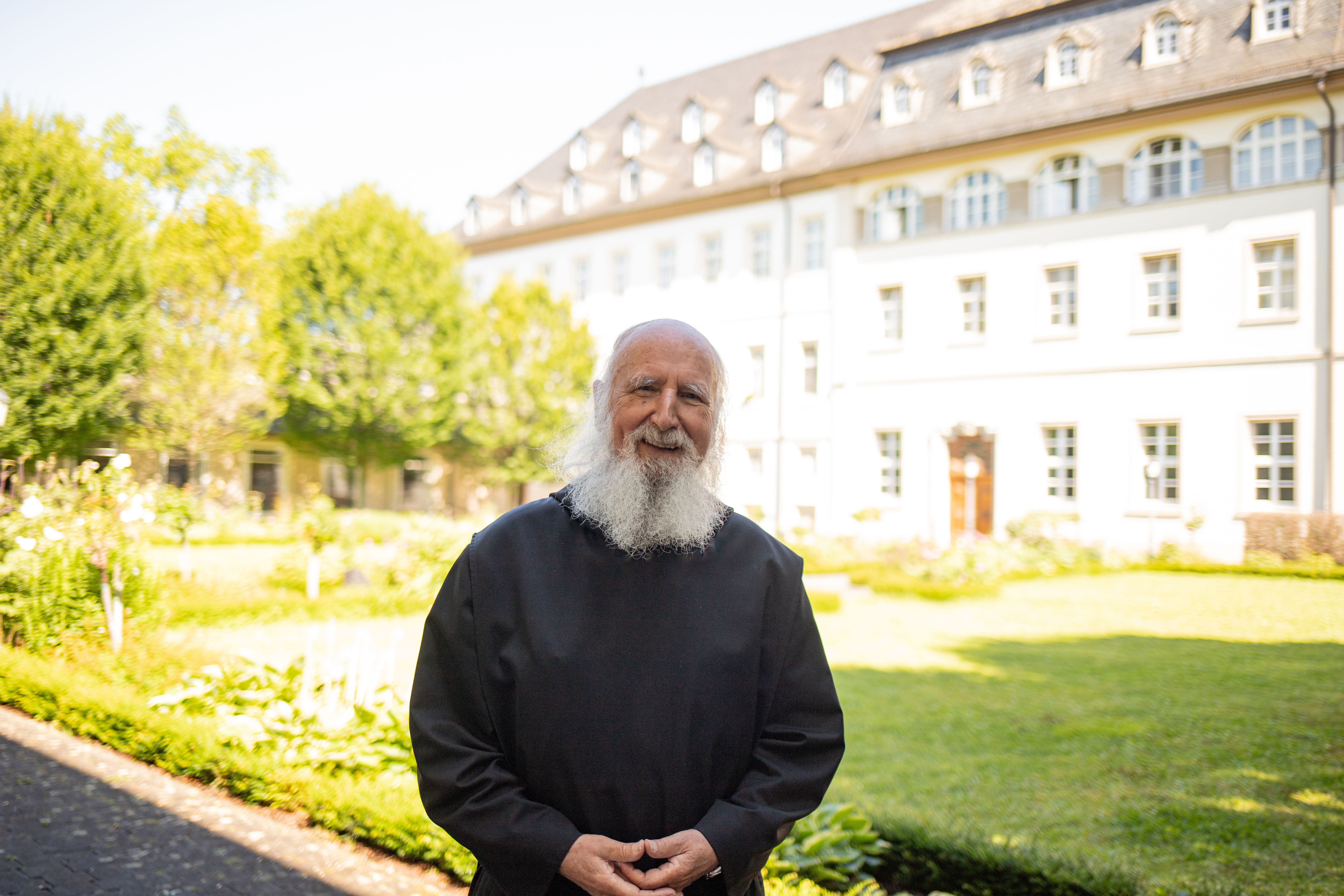Pater Anselm Grün vor Klosterlandschaft
