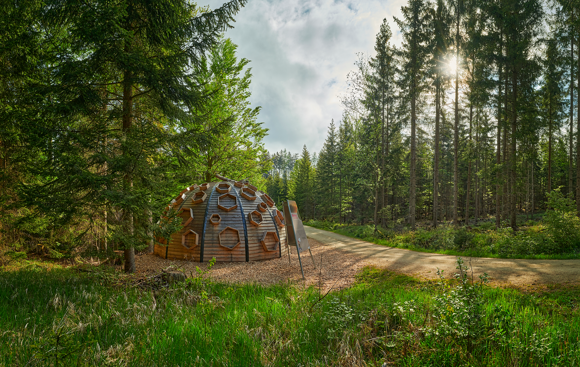 Umgeben von majestätischen Bäumen und sanften Hügeln, lädt die Moorkugel zu einer Auszeit in der Natur ein. Die harmonische Verbindung von Holz und Natur schafft eine einladende Atmosphäre, die Wanderer und Naturliebhaber gleichermaßen begeistert.