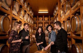Gruppe von Menschen in einem Lagerraum mit Whiskyfässern.