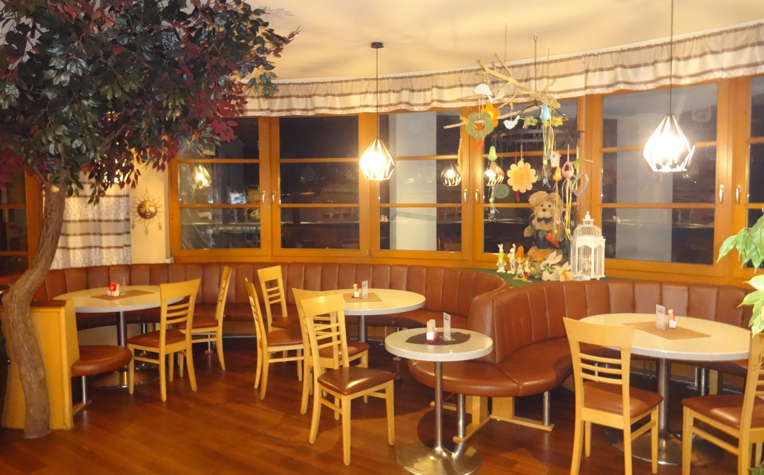 Gemütliches Café mit Holzmöbeln, Dekorationen und Pflanzen.