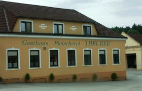 Außenansicht des Gasthauses und der Fleischerei Theurer mit gelber Fassade und braunem Dach.