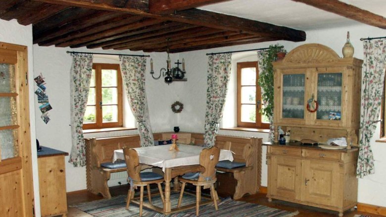 Rustikale Essecke mit Holzmöbeln und Teppichen in einem Ferienhaus.