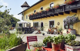Gem&uuml;tliches Gasthaus mit Blumenschmuck und Terrasse, l&auml;ndliche Atmosph&auml;re.